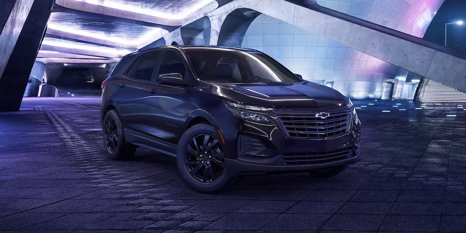 a black chevrolet equinox in a tunnel with neon lighting